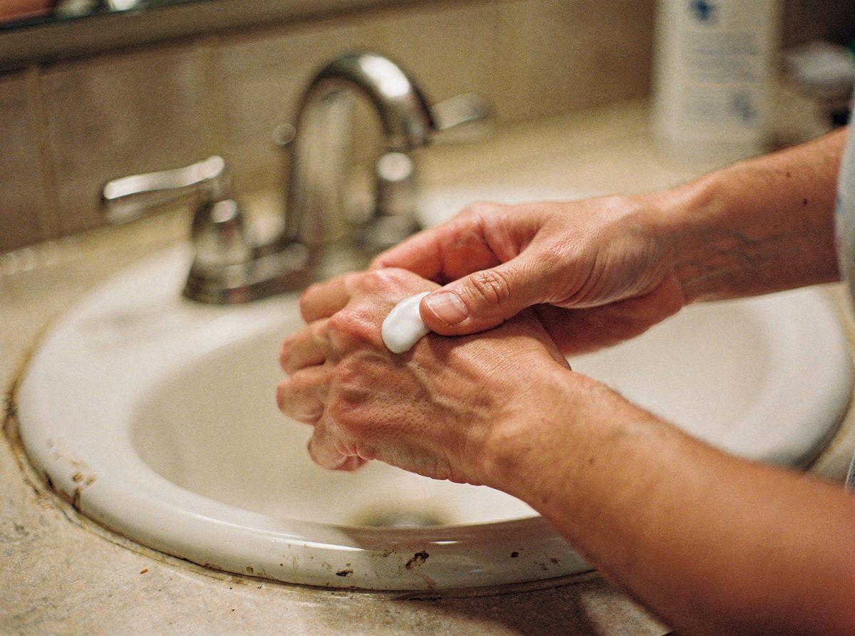 A person rubbing cream into the back of their hand