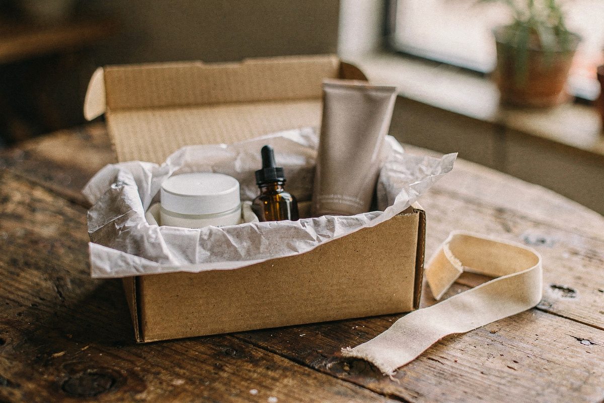 A boxed set of three skincare products with ribbon beside it